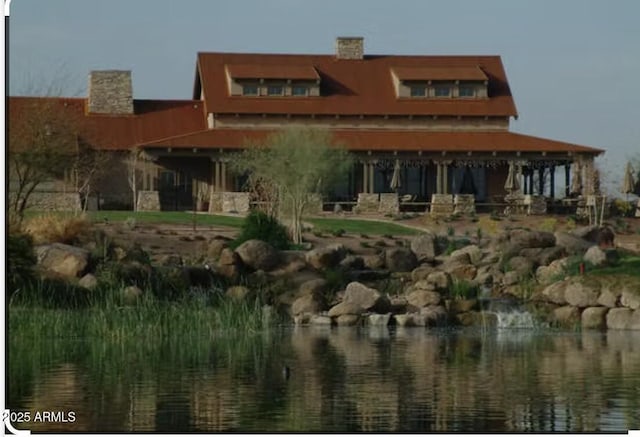 back of property featuring a water view