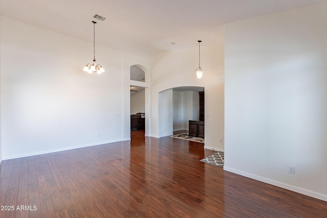 spare room featuring high vaulted ceiling and dark hardwood / wood-style flooring