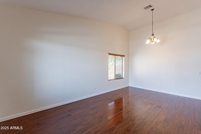 spare room featuring an inviting chandelier, high vaulted ceiling, and dark hardwood / wood-style floors