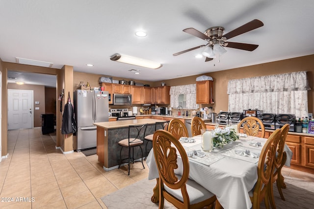 tiled dining space featuring ceiling fan and sink