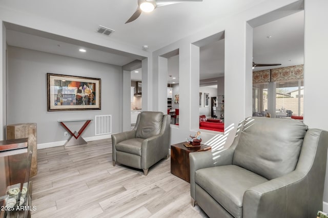 living area featuring ceiling fan and light hardwood / wood-style floors