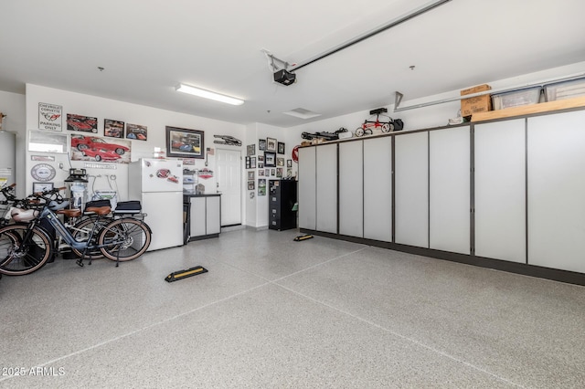 garage with white refrigerator and a garage door opener