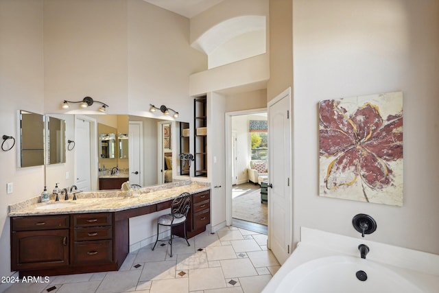 bathroom featuring a bathing tub, vanity, and a high ceiling