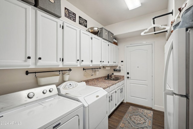 clothes washing area with cabinets, sink, washer and dryer, and dark hardwood / wood-style floors