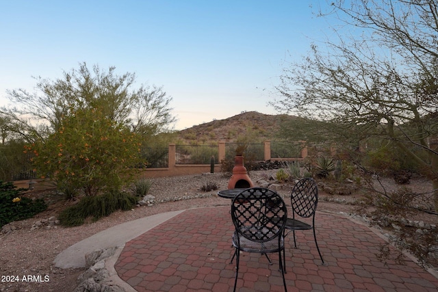 patio terrace at dusk featuring a mountain view