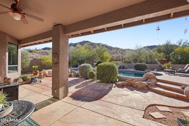 view of patio / terrace featuring a mountain view, a fenced in pool, and ceiling fan