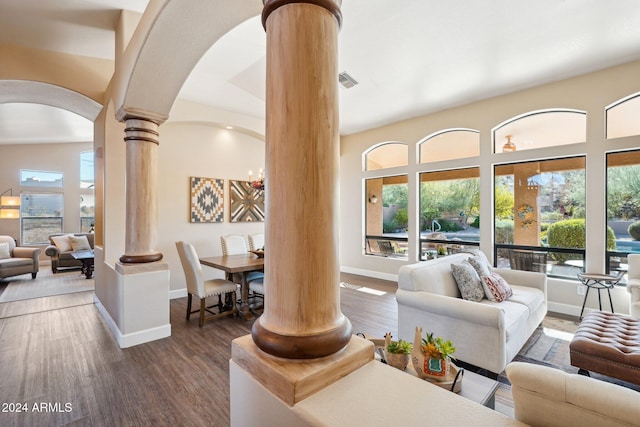 living room featuring lofted ceiling, ornate columns, plenty of natural light, and dark wood-type flooring