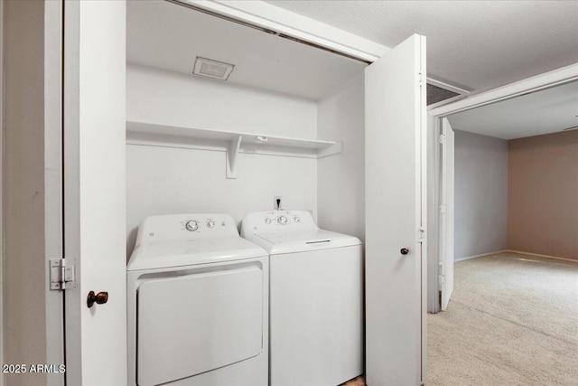 washroom with laundry area, independent washer and dryer, light colored carpet, visible vents, and baseboards