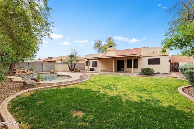 rear view of house with a yard, a fenced backyard, a patio, and stucco siding