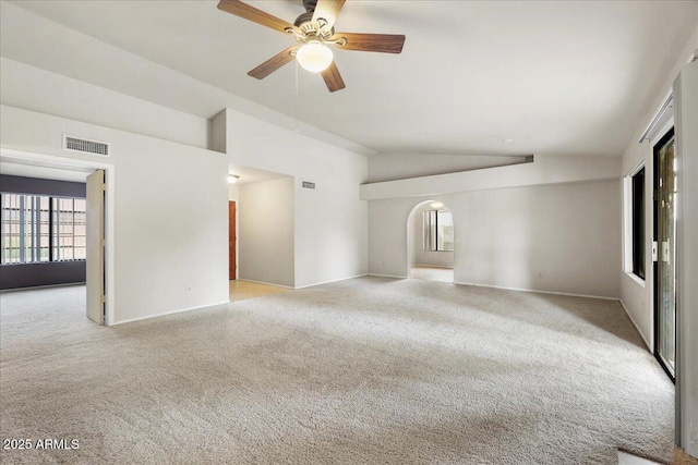 carpeted empty room with baseboards, visible vents, ceiling fan, and vaulted ceiling