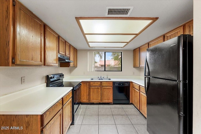 kitchen with visible vents, under cabinet range hood, brown cabinetry, black appliances, and light tile patterned flooring