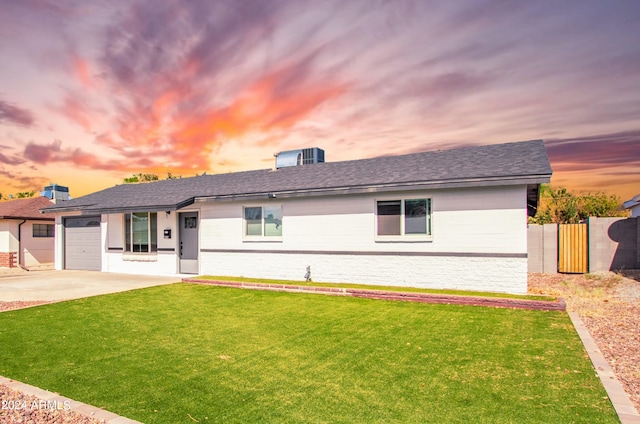 ranch-style home featuring a yard and a garage