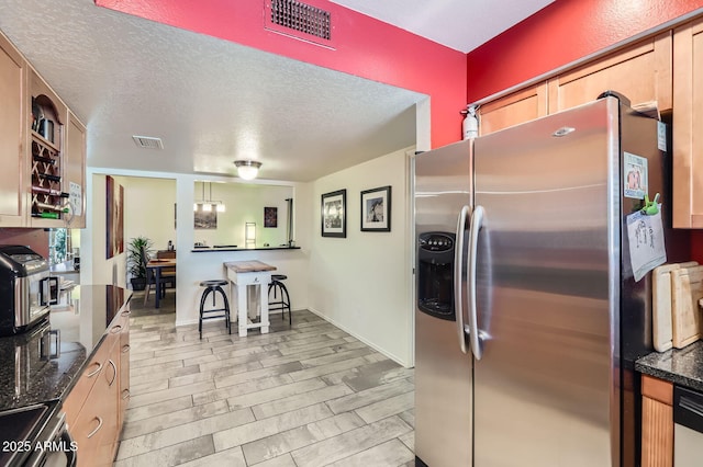 3924 E Cortez St, Phoenix, AZ 85028 - kitchen with stainless steel appliances, a textured ceiling, and dark stone counters