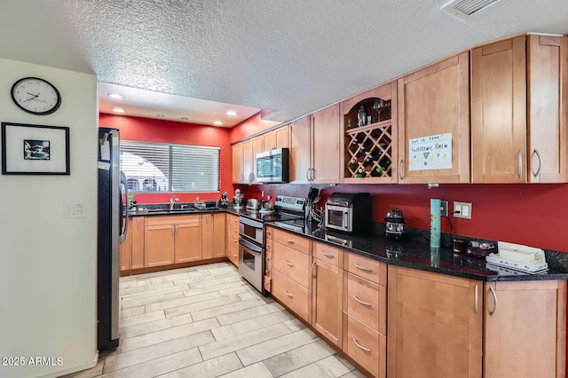 3924 E Cortez St, Phoenix, AZ 85028 - kitchen with stainless steel appliances, a textured ceiling, dark stone counters, and recessed lighting