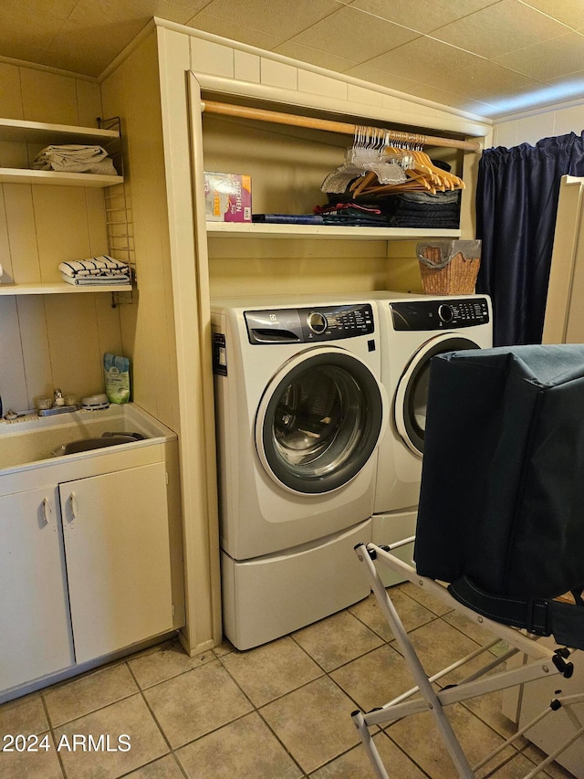 laundry room featuring light tile patterned floors, sink, and washing machine and clothes dryer