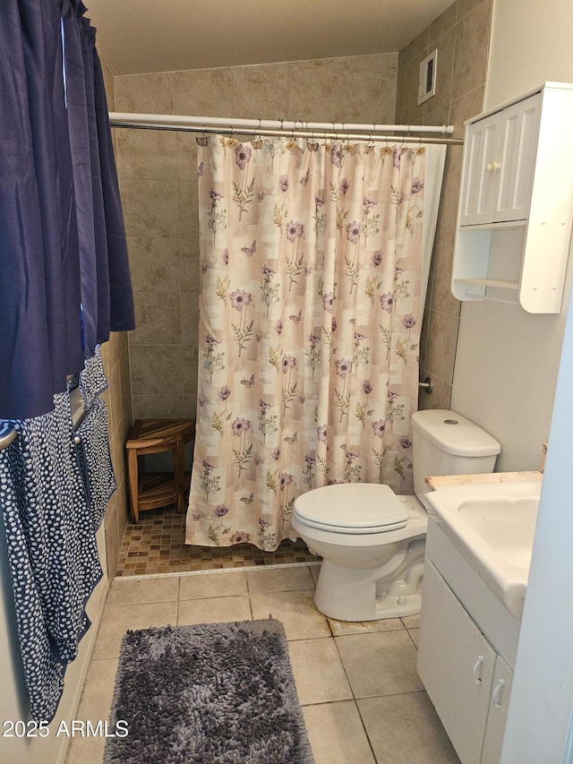 bathroom featuring toilet, a shower with shower curtain, tile patterned floors, and vanity