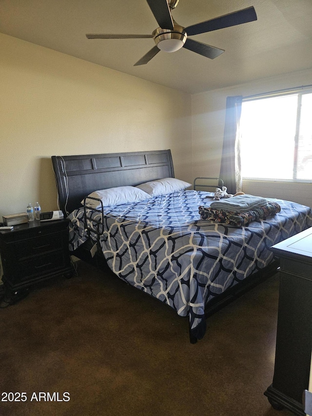 bedroom featuring ceiling fan and dark carpet