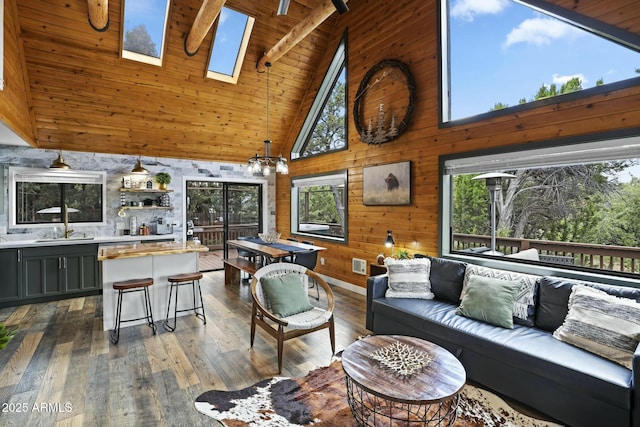 living room featuring wood walls, a skylight, beamed ceiling, dark wood-type flooring, and high vaulted ceiling