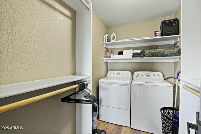 clothes washing area with hardwood / wood-style flooring and washer and dryer