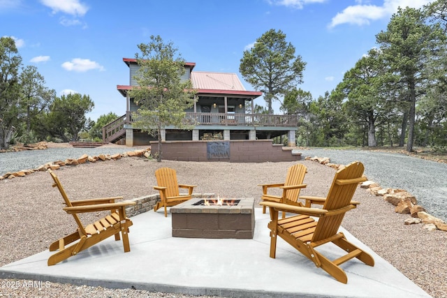 view of patio / terrace with a wooden deck and an outdoor fire pit