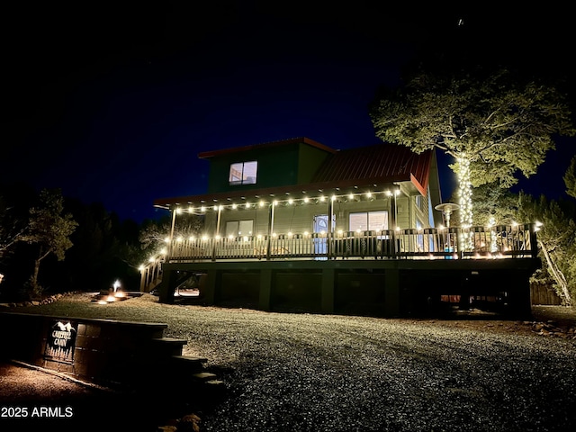 back house at twilight featuring a deck