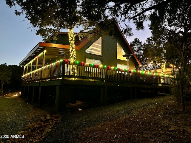 back house at dusk with a deck