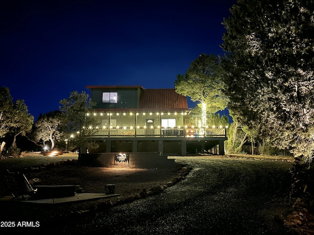 back house at night featuring a fire pit