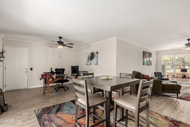 dining space featuring ceiling fan, ornamental molding, and light wood-type flooring