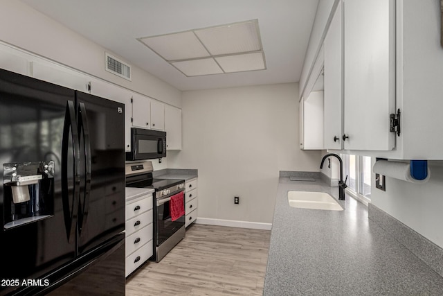 kitchen with white cabinetry, sink, light wood-type flooring, and black appliances