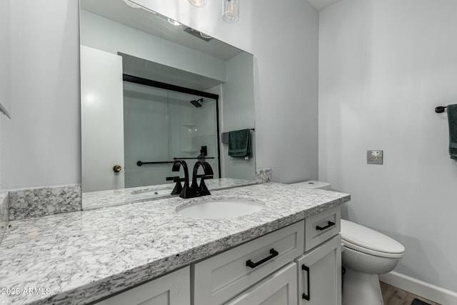 bathroom with an enclosed shower, vanity, hardwood / wood-style flooring, and toilet