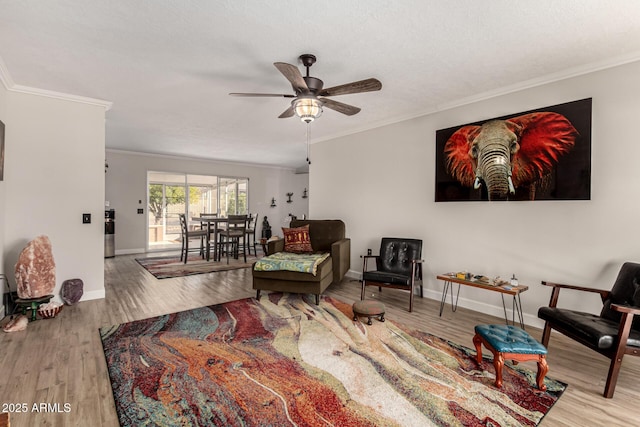 living room with crown molding, light hardwood / wood-style floors, and ceiling fan