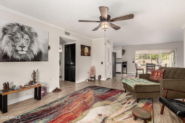 living room featuring ornamental molding, ceiling fan, and light hardwood / wood-style flooring