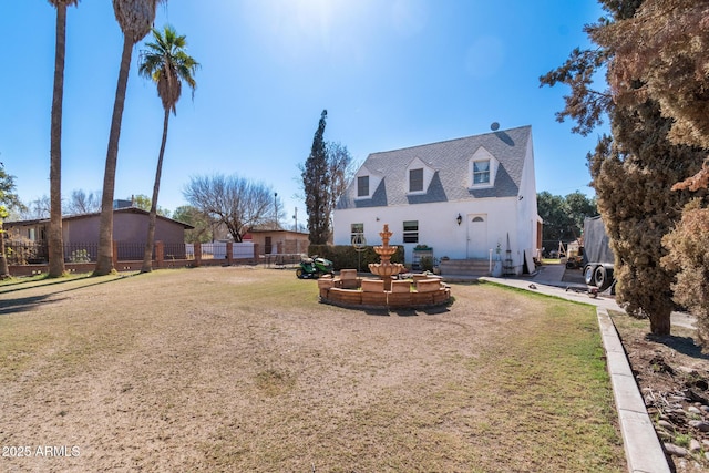 rear view of property with a yard and fence