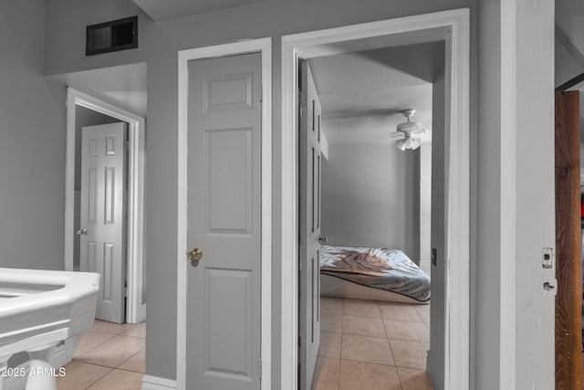 hall featuring light tile patterned floors and visible vents