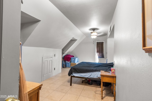 bedroom with tile patterned flooring, visible vents, and lofted ceiling