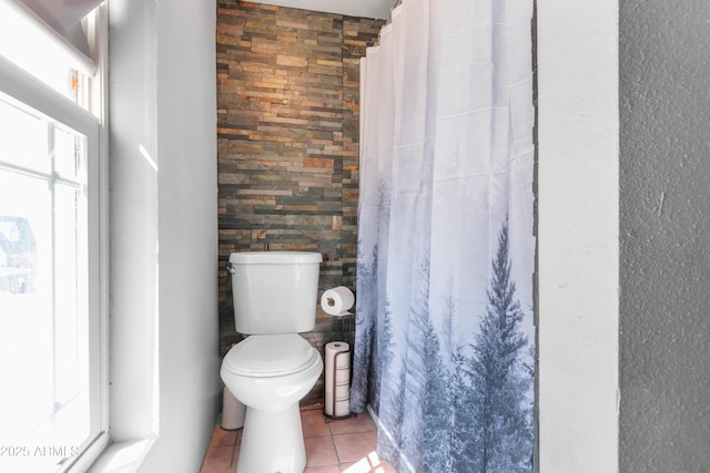 bathroom with curtained shower, toilet, and tile patterned flooring