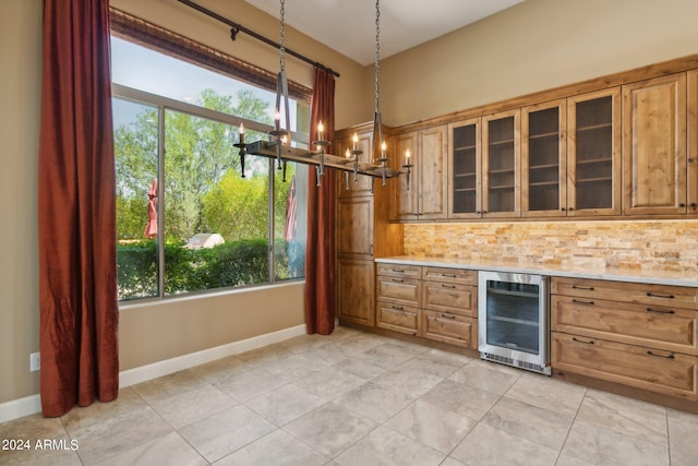 kitchen with light tile patterned flooring, tasteful backsplash, beverage cooler, decorative light fixtures, and a notable chandelier