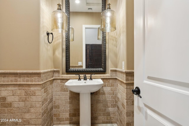 bathroom with tile walls and sink