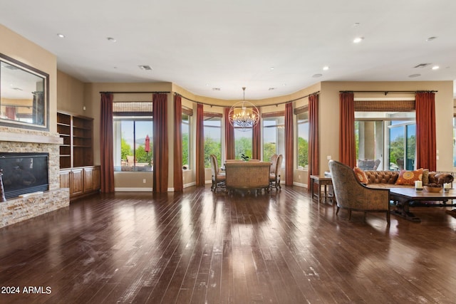 living room featuring a notable chandelier, dark hardwood / wood-style floors, and a fireplace