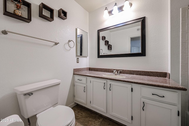 bathroom featuring vanity, tile patterned floors, and toilet