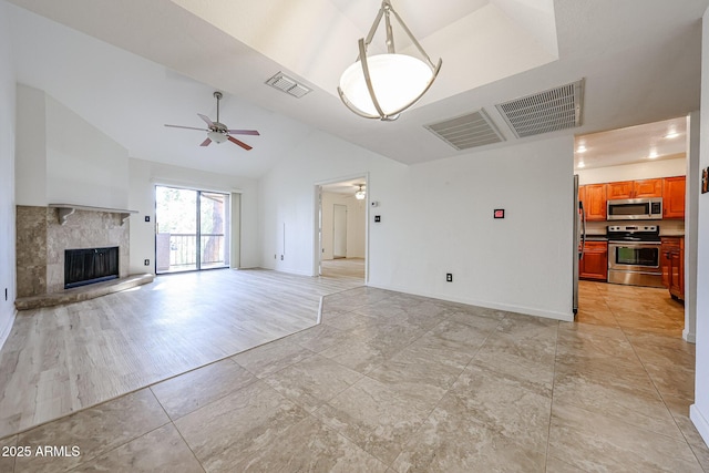 unfurnished living room with lofted ceiling, light tile patterned floors, and ceiling fan