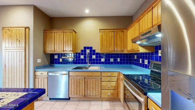 kitchen featuring stainless steel appliances, light tile patterned floors, tasteful backsplash, and sink