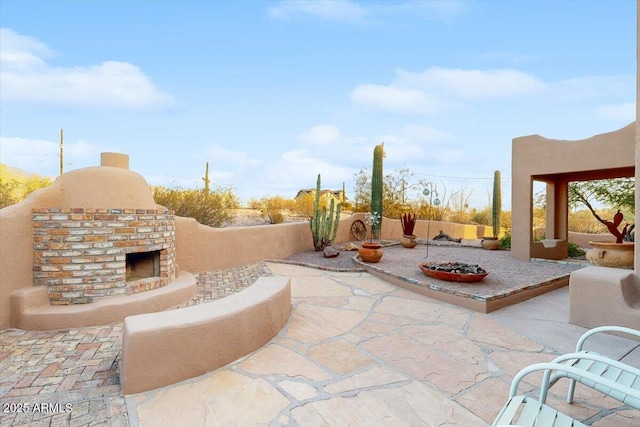 view of patio featuring an outdoor brick fireplace