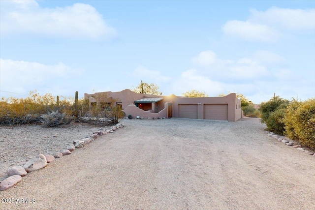 pueblo revival-style home featuring a garage