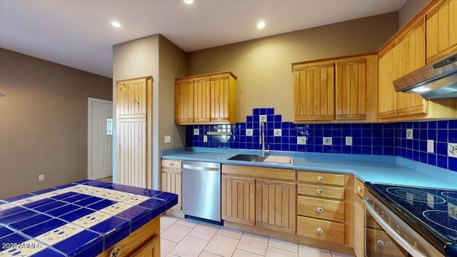 kitchen with tile counters, stainless steel appliances, light tile patterned floors, decorative backsplash, and sink