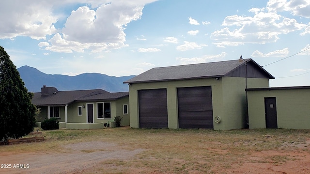 1005 W Purdy Ln, Bisbee, AZ 85603 - rear view of house with a garage, a mountain view, and driveway