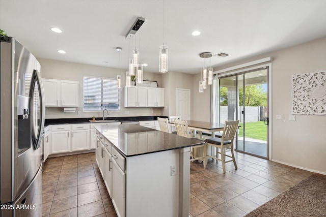 kitchen with stainless steel fridge with ice dispenser, recessed lighting, a kitchen island, decorative light fixtures, and a sink