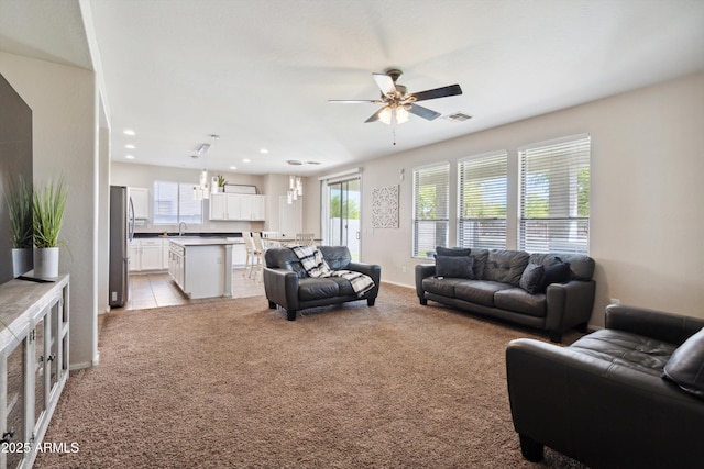 living room with ceiling fan, light colored carpet, visible vents, recessed lighting, and light tile patterned flooring