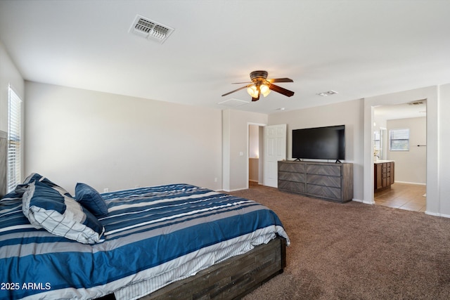 carpeted bedroom with visible vents, baseboards, and ceiling fan
