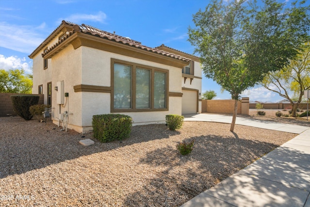 view of front of property with fence, stucco siding, a garage, and concrete driveway
